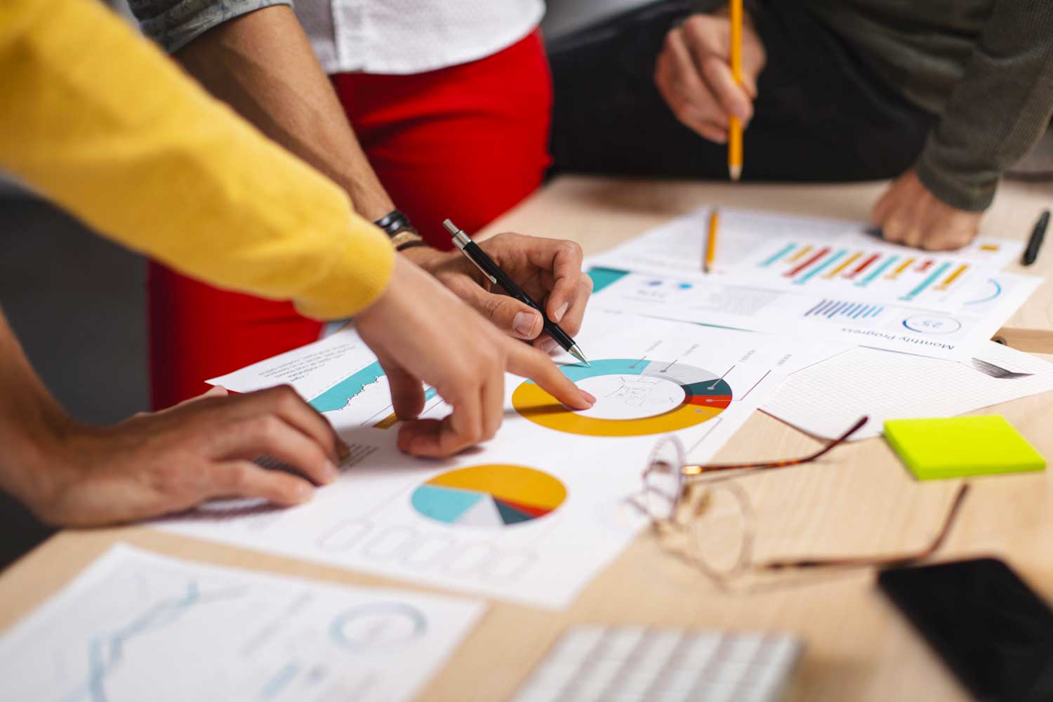 team pointing at graphics on a table