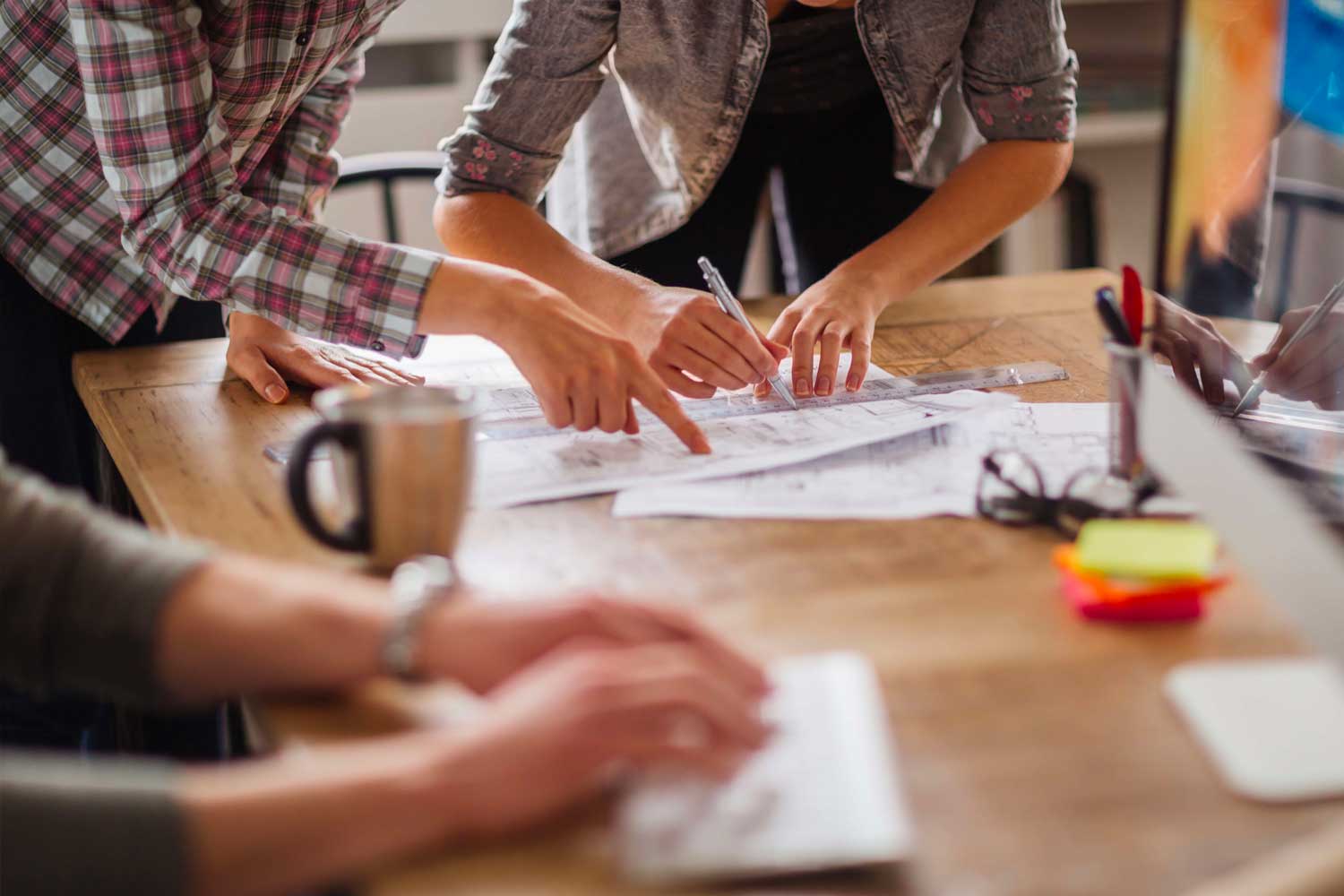 team pointing at logo desgins on a table